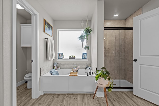 1215 E 93rd St, Odessa, TX 79765 - bathroom with a stall shower, toilet, a garden tub, and wood finished floors