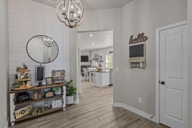 1215 E 93rd St, Odessa, TX 79765 - hallway with a chandelier, light wood-type flooring, and baseboards
