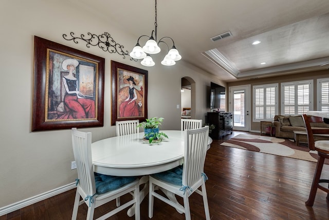 7302 Giotto St, Odessa, TX 79765 - dining room featuring arched walkways, dark wood finished floors, a tray ceiling, baseboards, and a chandelier