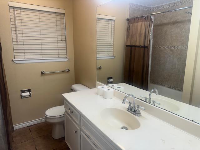 606 NW 14th St, Andrews, TX 79714 - bathroom featuring vanity, tile patterned floors, and shower / bath combo