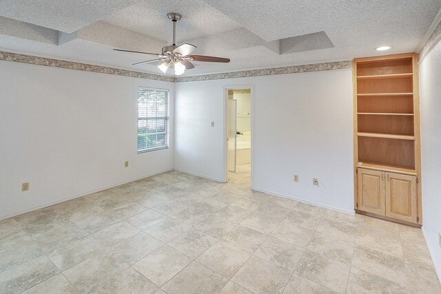 1203 S Nelson Ave, Monahans, TX 79756 - unfurnished room with built in shelves, ceiling fan, and a textured ceiling
