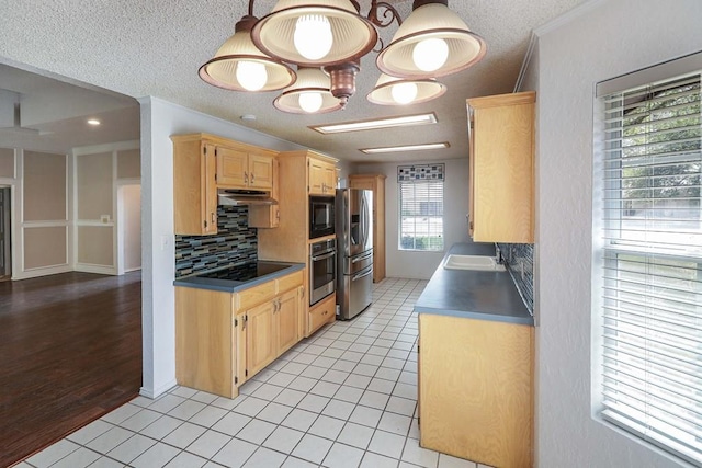 1203 S Nelson Ave, Monahans, TX 79756 - kitchen featuring black appliances, light brown cabinets, decorative backsplash, a sink, and a textured ceiling