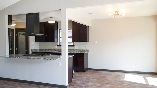 4603 N Tom Green Ave, Odessa, TX 79762 - kitchen featuring island range hood, gas cooktop, wood finished floors, and dark brown cabinetry