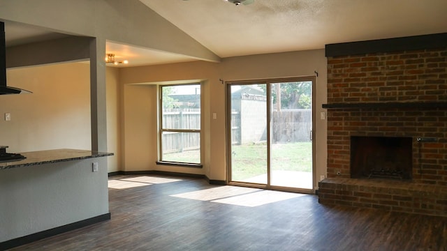 4603 N Tom Green Ave, Odessa, TX 79762 - unfurnished living room with dark wood finished floors, healthy amount of natural light, lofted ceiling, and a fireplace