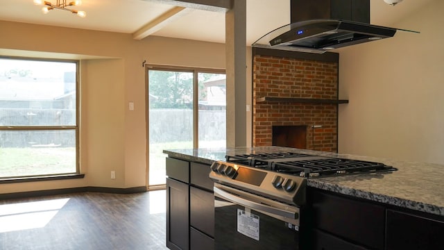 4603 N Tom Green Ave, Odessa, TX 79762 - kitchen featuring stainless steel gas stove, ventilation hood, wood finished floors, a brick fireplace, and dark stone countertops