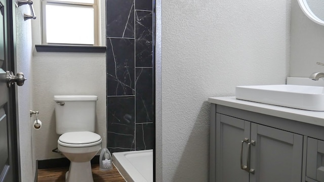 4603 N Tom Green Ave, Odessa, TX 79762 - full bath featuring vanity, a shower, wood finished floors, and a textured wall