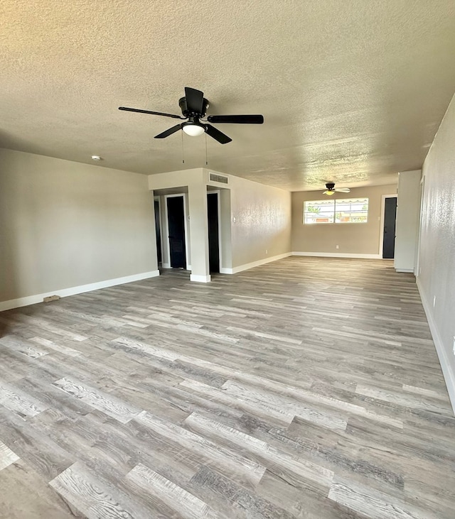 2410 E 25th St, Odessa, TX 79762 - unfurnished living room with ceiling fan, a textured ceiling, wood finished floors, and baseboards