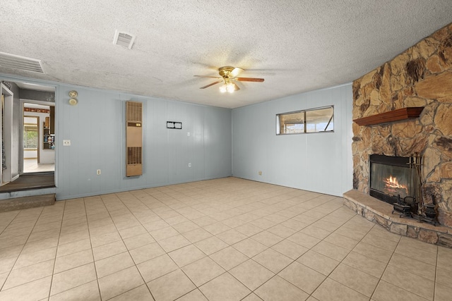 4530 W Morris St, Odessa, TX 79764 - unfurnished living room with ceiling fan, plenty of natural light, a stone fireplace, and a textured ceiling