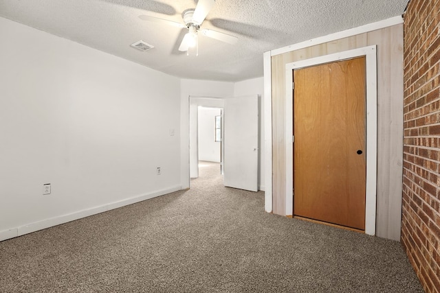 4530 W Morris St, Odessa, TX 79764 - unfurnished bedroom featuring carpet flooring, a closet, brick wall, a textured ceiling, and a ceiling fan