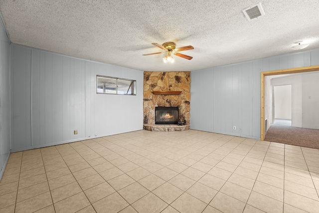 4530 W Morris St, Odessa, TX 79764 - unfurnished living room with a ceiling fan, a stone fireplace, and a textured ceiling