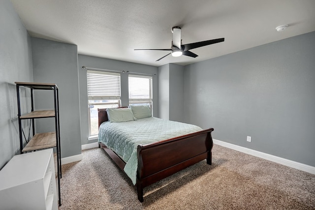 carpeted bedroom featuring ceiling fan and a textured ceiling