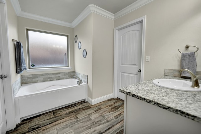 bathroom featuring hardwood / wood-style floors, ornamental molding, a bathtub, and vanity