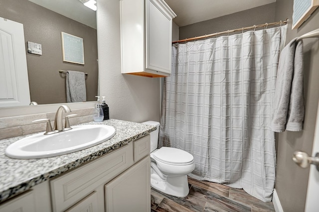 bathroom featuring wood-type flooring, vanity, and toilet