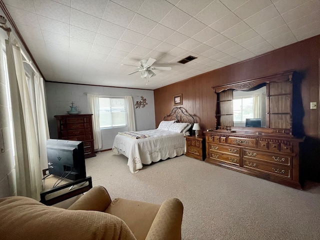 carpeted bedroom featuring multiple windows and ceiling fan