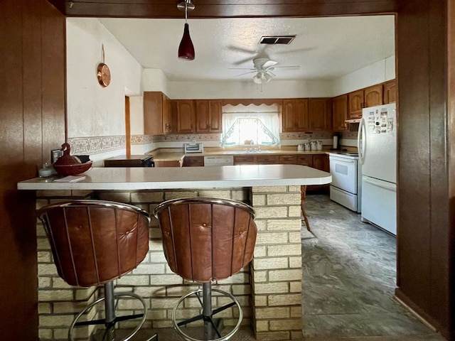 kitchen with a breakfast bar area, kitchen peninsula, ceiling fan, and white appliances