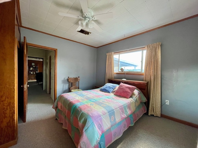 carpeted bedroom with ceiling fan and ornamental molding