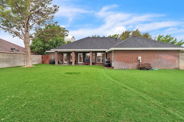 1000 S Nelson Rd, Monahans, TX 79756 - back of house featuring roof with shingles, brick siding, a fenced backyard, and a chimney