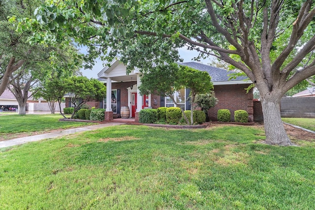 1000 S Nelson Rd, Monahans, TX 79756 - view of property hidden behind natural elements featuring brick siding, a front yard, and a shingled roof