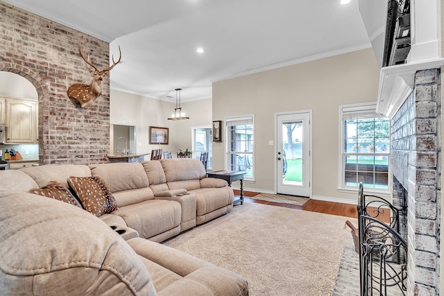 1000 S Nelson Rd, Monahans, TX 79756 - living room featuring a fireplace, recessed lighting, a chandelier, wood finished floors, and ornamental molding