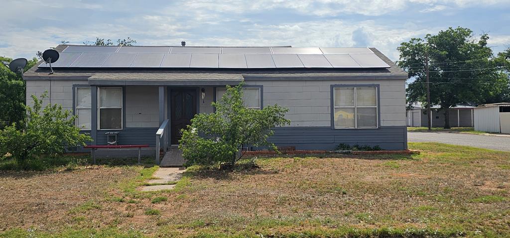1011 NW 6th St, Andrews, TX 79714 - view of front of home featuring roof mounted solar panels and a front yard