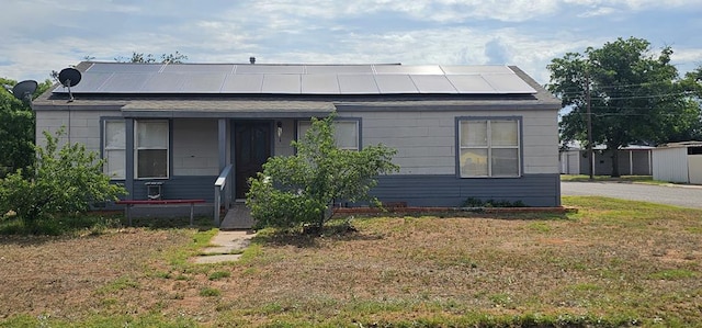 1011 NW 6th St, Andrews, TX 79714 - view of front of home featuring roof mounted solar panels and a front yard