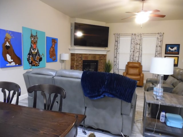 living room with a brick fireplace and ceiling fan