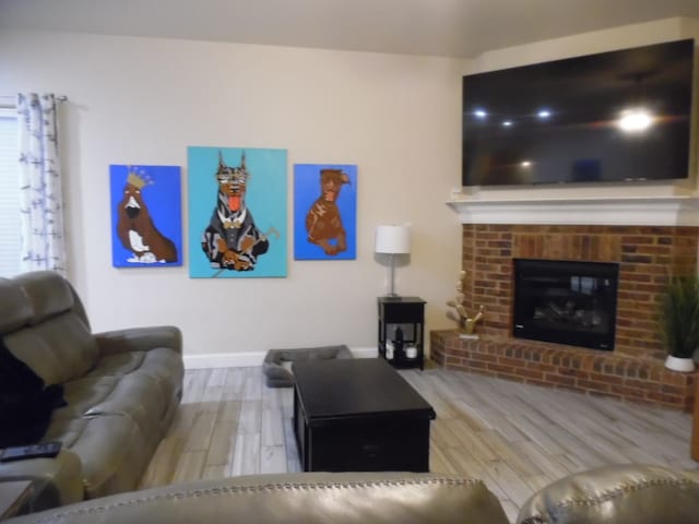 living room with hardwood / wood-style flooring and a brick fireplace