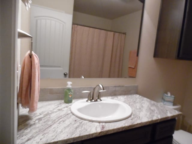 bathroom featuring vanity, toilet, and walk in shower