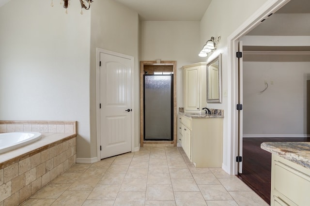 259 County Rd 304, Seminole, TX 79360 - bathroom with vanity, a shower stall, a garden tub, and baseboards