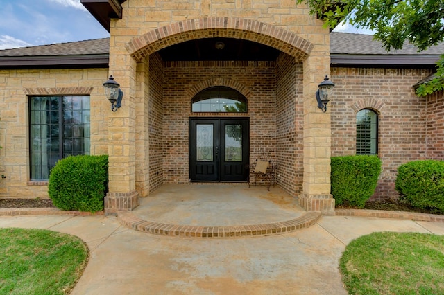 259 County Rd 304, Seminole, TX 79360 - doorway to property featuring french doors, a shingled roof, and brick siding