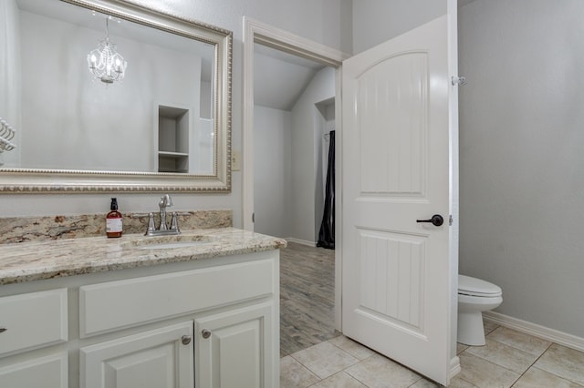 259 County Rd 304, Seminole, TX 79360 - bathroom featuring vanity, toilet, lofted ceiling, tile patterned flooring, and baseboards