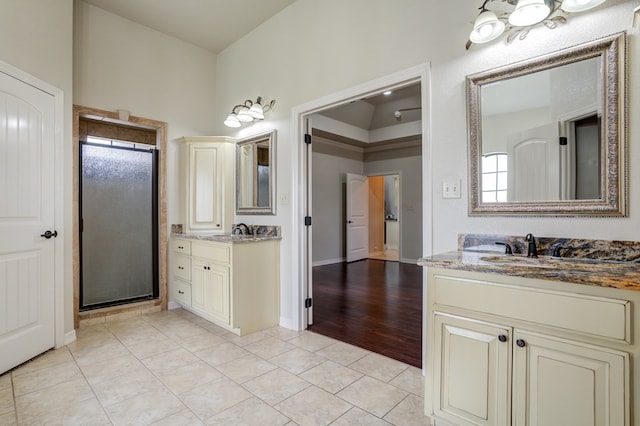 259 County Rd 304, Seminole, TX 79360 - full bath featuring a shower stall, two vanities, tile patterned floors, and baseboards