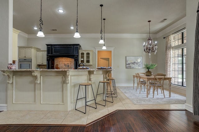 259 County Rd 304, Seminole, TX 79360 - kitchen featuring oven, cream cabinets, ornamental molding, light stone counters, and baseboards