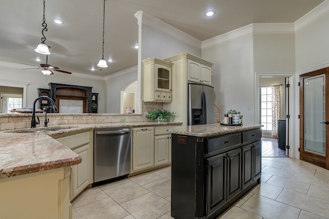 259 County Rd 304, Seminole, TX 79360 - kitchen with cream cabinets, appliances with stainless steel finishes, a sink, backsplash, and a ceiling fan