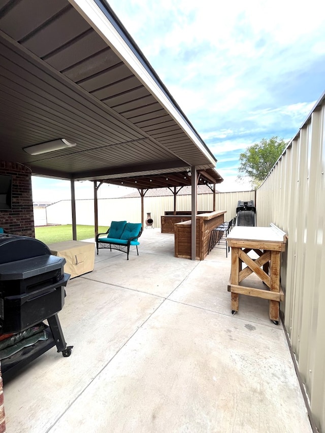view of patio / terrace with a fenced backyard, area for grilling, and a hot tub