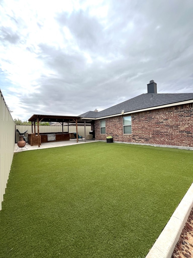 back of property featuring a gazebo, a patio, brick siding, a shingled roof, and a chimney