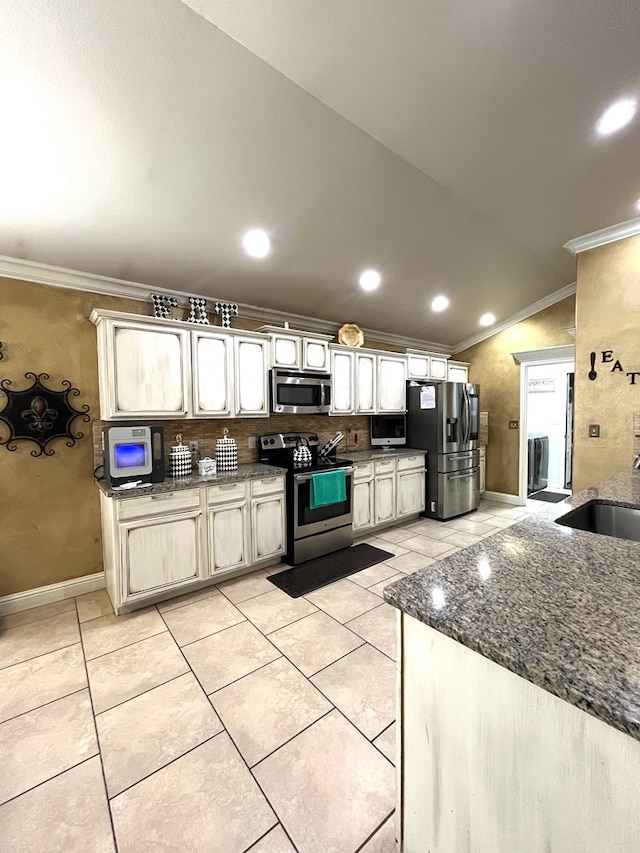 kitchen featuring stainless steel appliances, ornamental molding, light tile patterned flooring, a sink, and lofted ceiling