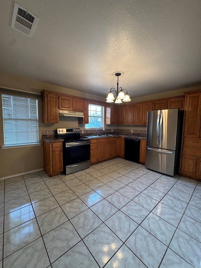3811 Henderson Ave, Odessa, TX 79762 - kitchen featuring stainless steel appliances, dark countertops, a chandelier, under cabinet range hood, and a textured ceiling