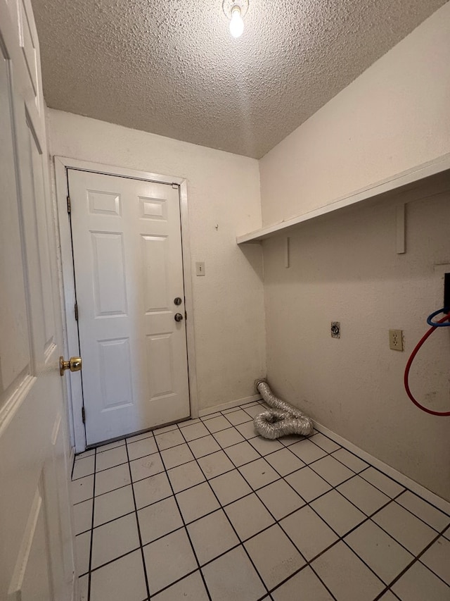 3811 Henderson Ave, Odessa, TX 79762 - washroom featuring hookup for an electric dryer, a textured ceiling, and light tile patterned floors