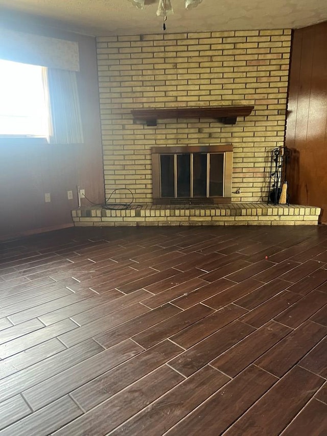 3805 E Everglade Ave, Odessa, TX 79762 - unfurnished living room featuring a brick fireplace and wood finished floors