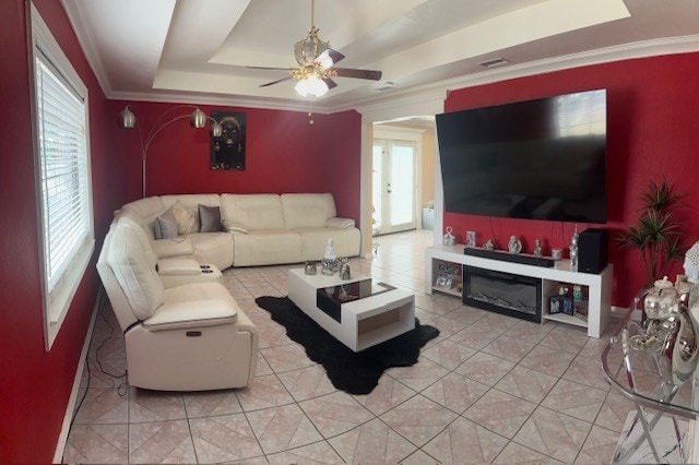 2404 W 10th St, Odessa, TX 79763 - living area featuring ceiling fan, a raised ceiling, ornamental molding, a glass covered fireplace, and light tile patterned flooring