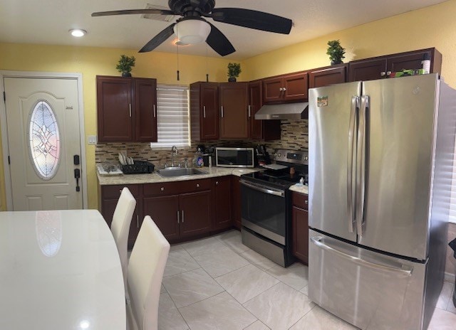 2404 W 10th St, Odessa, TX 79763 - kitchen with appliances with stainless steel finishes, range hood, a sink, light countertops, and tasteful backsplash