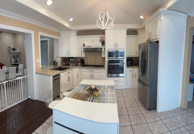 2404 W 10th St, Odessa, TX 79763 - kitchen featuring appliances with stainless steel finishes, a sink, white cabinets, a chandelier, and hanging light fixtures