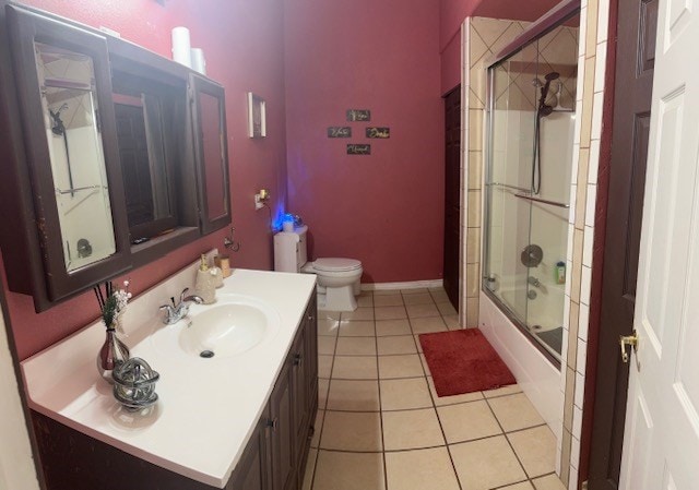 2404 W 10th St, Odessa, TX 79763 - full bathroom featuring vanity, toilet, tile patterned flooring, bath / shower combo with glass door, and baseboards