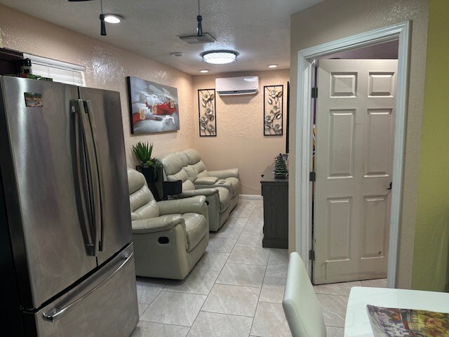 2404 W 10th St, Odessa, TX 79763 - living area with a textured wall, a wall unit AC, and a textured ceiling