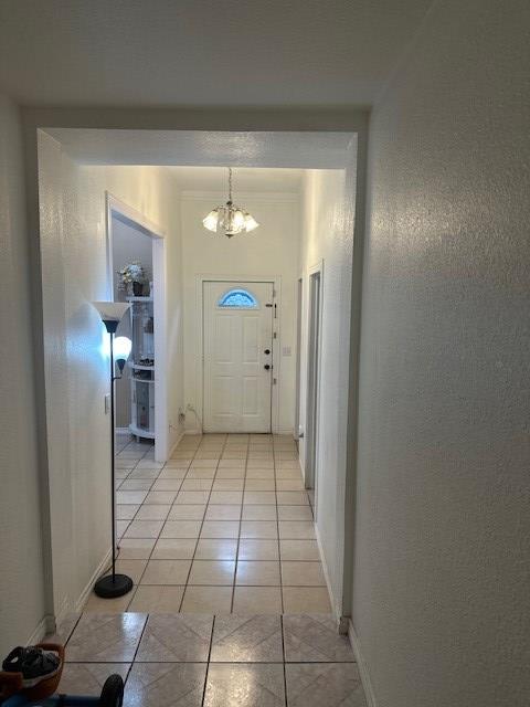 2404 W 10th St, Odessa, TX 79763 - entryway with a chandelier, light tile patterned floors, and baseboards