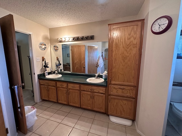 bathroom with vanity, a textured ceiling, and tile patterned floors