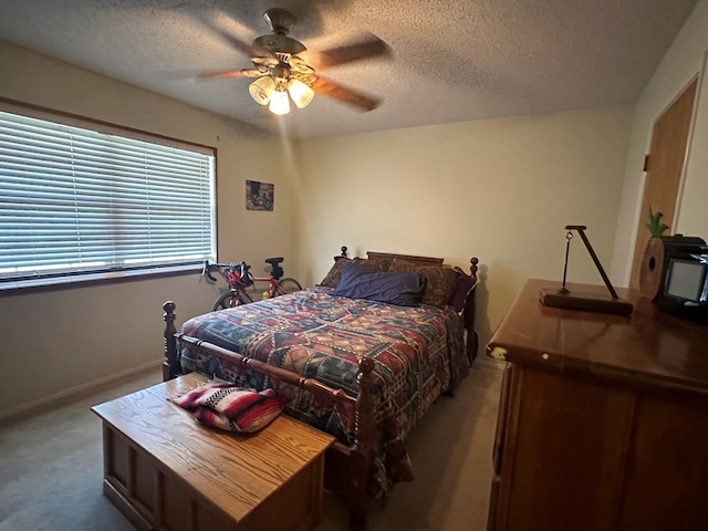 carpeted bedroom with ceiling fan and a textured ceiling