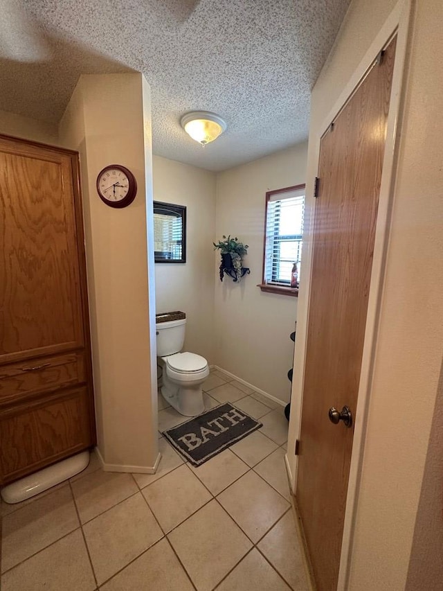 bathroom with tile patterned floors, a textured ceiling, and toilet