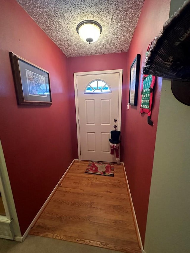 doorway to outside featuring wood-type flooring and a textured ceiling